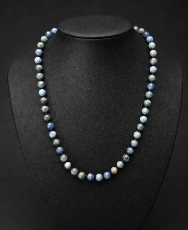 Colar de cianita azul natural em bolas exibido em busto de joalheria.