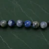 Detalhe das contas de cianita azul natural polidas.