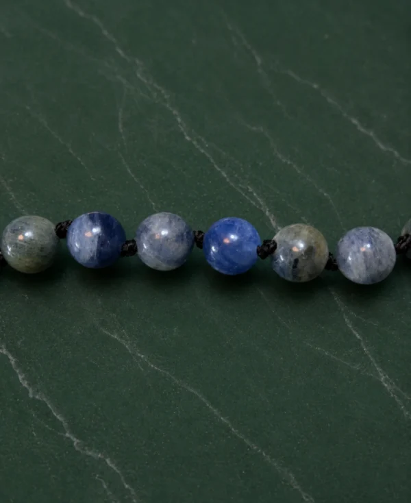 Detalhe das contas de cianita azul natural polidas.