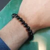 Pulseira de Azeviche natural 8 mm sendo usada para demonstrar o tamanho e o caimento no pulso.