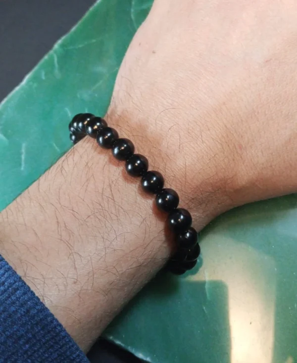 Pulseira de Azeviche natural 8 mm sendo usada para demonstrar o tamanho e o caimento no pulso.